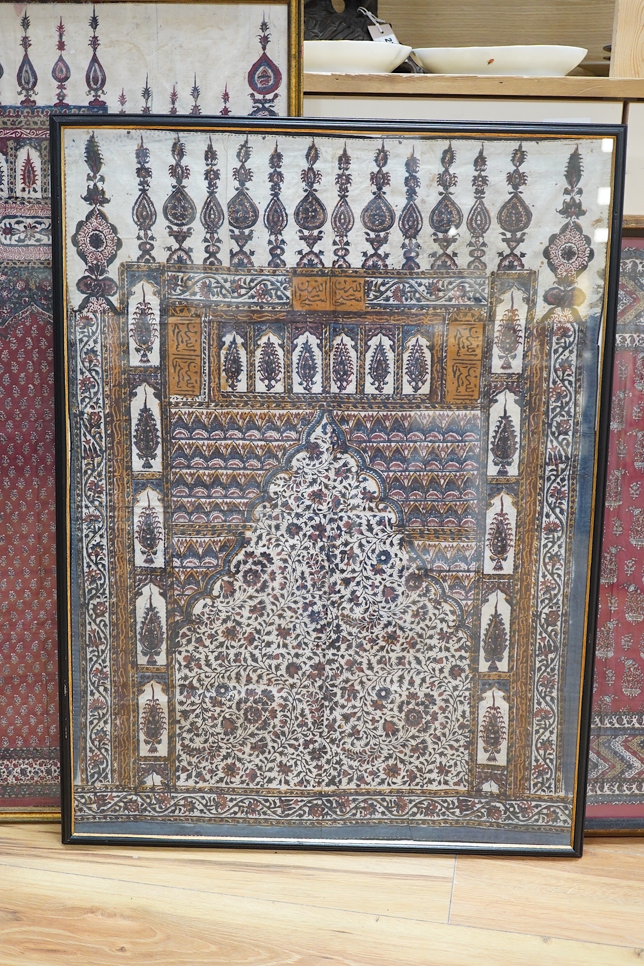 Two framed 19th century Indian Kalamkari boteh block printed prayer Niches, possibly from Machilitanam and a similar framed block printed square, possibly part of a table cover, largest 53cm wide x 67cm high (3). Conditi